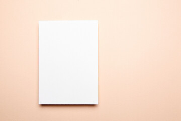 Greeting card mockup beige background, top view, flat lay. Blank holiday card or flyer