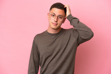 Young Brazilian man isolated on pink background with an expression of frustration and not understanding