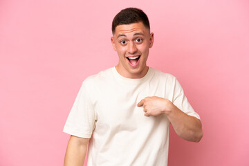 Young Brazilian man isolated on pink background with surprise facial expression
