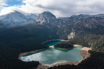 Aerial view of Durmitor national park and black lake snow on top of mountains and clouds on sky