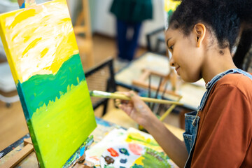 African kid drawing in classroom, young girl happy funny study and play painting acrylic color on canvas.Group of  children drawing with  teacher in school studio.