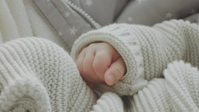 Close-up hand of a sleeping baby in white bed and her wag of the finger. Ultra high definition UHD video