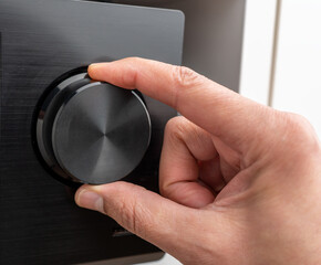 Hand turning the volume knob of an amplifier up to the maximum, Concept for noisy environment or...