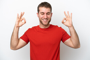 Young caucasian man isolated on white background in zen pose