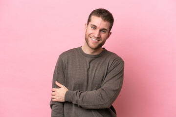 Young caucasian man isolated on pink background laughing