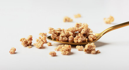 Granola on spoon on light background.