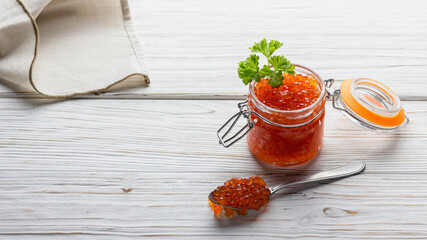 Red caviar in a jar with spoon