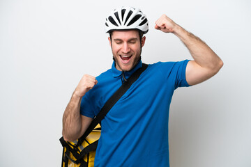 Young caucasian man with thermal backpack isolated on white background celebrating a victory