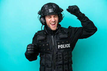 SWAT caucasian man isolated on blue background celebrating a victory