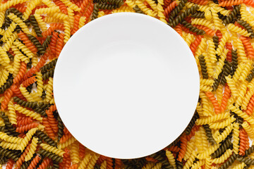 Raw pasta torti texture and white bowl.