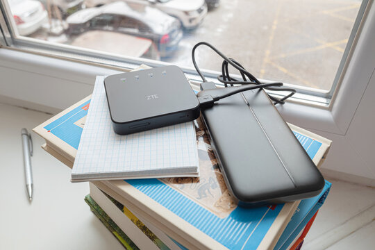 Kyiv, Ukraine- 18 January 2023: Small 3g 4g mobile wireless ZTE internet router with power bank on window at home. To connect to the internet for online learning and working during a blackout.