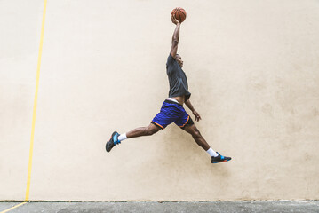 Athletic african american basketball player training on a court in New York - Sportive man playing basket outdoors - obrazy, fototapety, plakaty