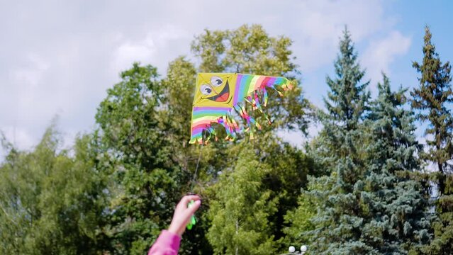 A kite on a string is pulled by a child in the city. Children's entertainment