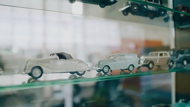 There are models of various cars on a glass shelf in the museum. Close-up shooting