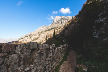 Kotor, Montenegro, process of climbing to the top of San Giovanni Fortress, Fort St. John, old medieval town, hiking on the Ladder of Kotor, sunny day with a blue sky and mount Lovcen and Orjen