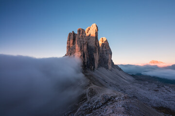 Felsmassiv, die Drei Zinnen, in den Dolomiten in Südtirol in den Alpen mit Fels im Sonnenlicht und Nebel.