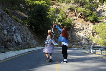 Romantic scene with happy hipster couple dancing in the middle of empty switchback road. Young...