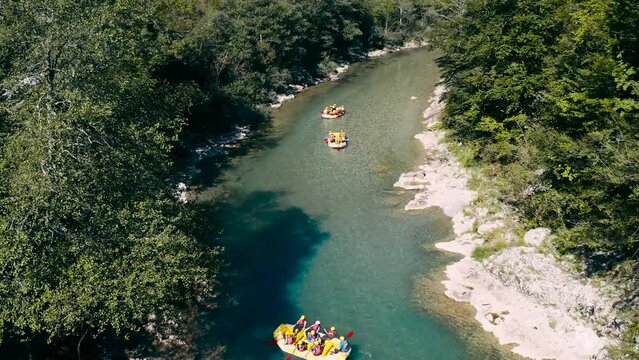 People are rafting the river on the boat.Tara river rafting.4k drone shot over the Tara canyon in Montenegro.Limpid fresh clean river water and rocks.Calm nature scenery of Montenegro and wild sport.