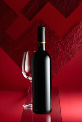 Bottle of red wine and an empty wine glass.