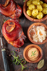 Tasty roasted pork knuckle served with potatoes and pickled cabbage.