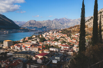 Obraz premium Kotor, Montenegro, process of climbing to the top of San Giovanni Fortress, Fort St. John, old medieval town, hiking on the Ladder of Kotor, sunny day with a blue sky and mount Lovcen and Orjen