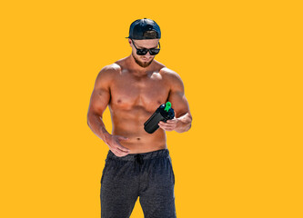 Portrait of a handsome halfnacked bodybuilder man on a mountain with a bottle of water.