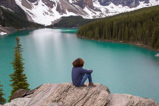 High angle view of hiker sitting on rock against Moraine Lake