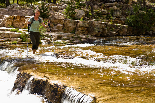 A woman wades across the Provo River in Utah's Uinta Mountains.