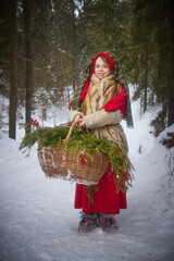 Nice cute teenager girl in old peasant clothes with hot fur coat and shawl in cold winter forest...
