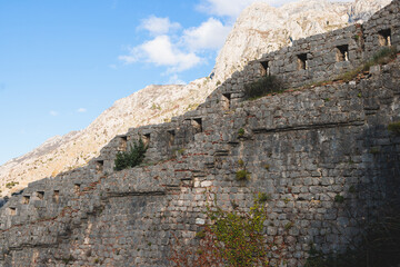 Kotor, Montenegro, process of climbing to the top of San Giovanni Fortress, Fort St. John, old medieval town, hiking on the Ladder of Kotor, sunny day with a blue sky and mount Lovcen and Orjen