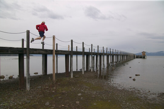 A man running on a pier on Lake Tahoe in Tahoe City, CA.