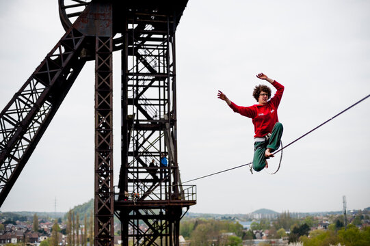 Highliner balancing on tightrope on mine shaft tower, Charleroi, Wallonia, Belgium