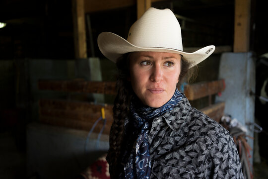 Woman in cowboy hat in barn