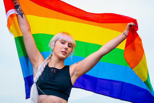 Lesbian woman with the flag of pride in sportswear at gay parade