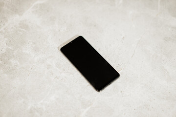 Black phone on shinny marble surface background