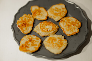 Small yellow mini banana pancakes on grey dish