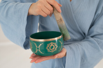 Asian woman playing Tibetan singing bowl. 