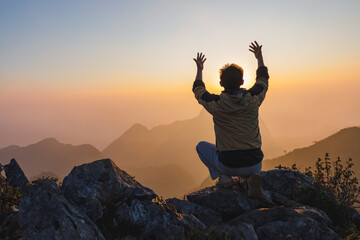 Male Travel praying alone on top mountain sunset background Lifestyle spiritual relaxation...