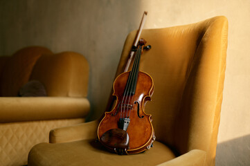 Fototapeta na wymiar Violin musical instrument left by musician on chair