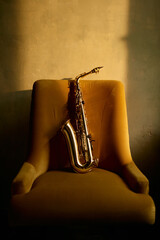 Saxophone musical instrument left on chair in retro room