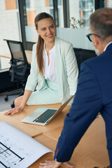 Cheerful woman in elegant suit interacting with business partner