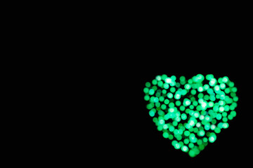 Green heart of glitter circles lights as an abstract Valentines Day festive background with copy space