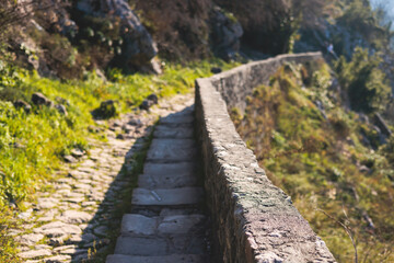 Kotor, Montenegro, process of climbing to the top of San Giovanni Fortress, Fort St. John, old medieval town, hiking on the Ladder of Kotor, sunny day with a blue sky and mount Lovcen and Orjen