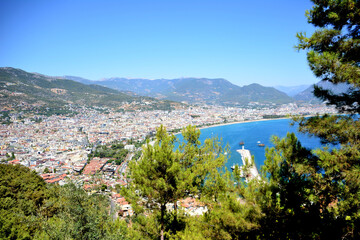 Fototapeta na wymiar Alanya town with mediterranean sea, sea port, mountains and pine trees, viewpoint