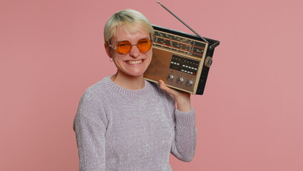 Millennial woman with short hair using retro tape record player to listen music, disco dancing of...