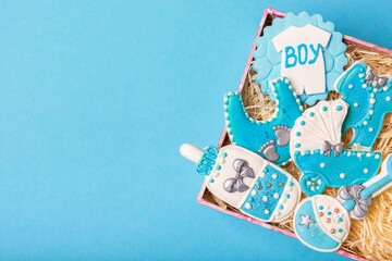 Set of delicious baby shower cookies in a gift box on a blue background. Gender cookies.Baby shower party. Close-up. Flat lay. Place for text.