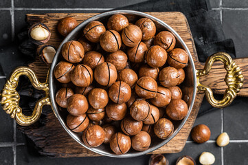 Macadamia nuts in a shell ready to eat. Black background. Top view