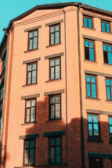 Fototapeta na wymiar Modern windows in brown frames on red brick wall of industrial building. Loft inspiration. Construction facade concept.