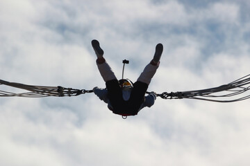 Woman makes selfie in mid-air, hanging on a bungee ropes