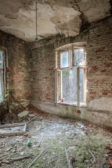 Fototapeta premium Abandoned and abandoned building in ruin, view of an open and cracked window